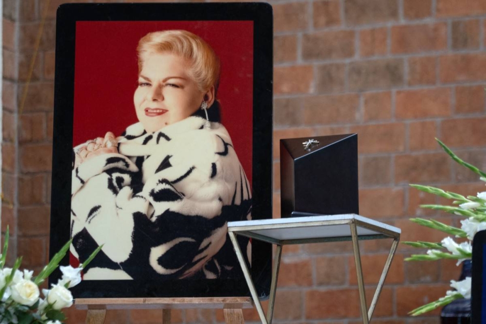 Nietos de Paquita llevan su urna. Photo by VICTORIA RAZO / AFP