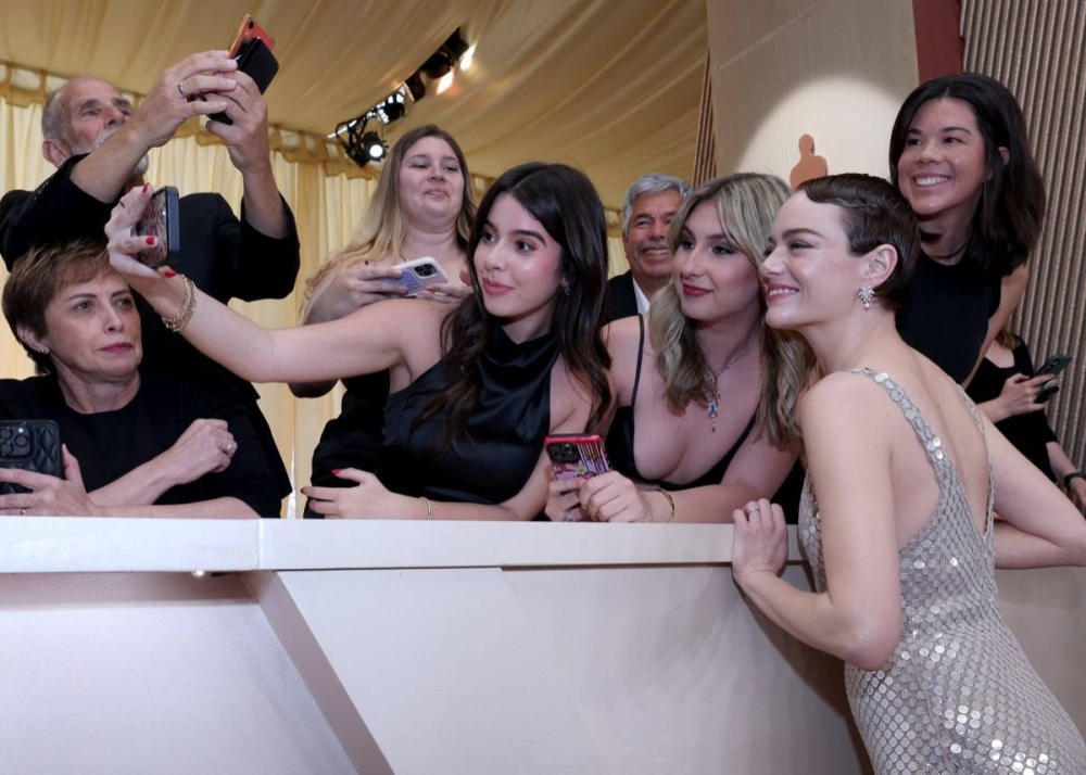 Emma Stone siempre tiene un momento para conceder una foto a sus fans. Photo by VALERIE MACON / AFP