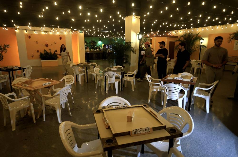 Personas visitan una sala de juego de dominó en la experiencia inmersiva en Puerto Rico. EFE/ Thais Llorca