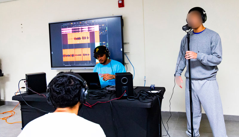 Fotografía cedida este domingo, 20 de julio, por la Fundación Rimas en la que aparecen un par de jóvenes presos (i y d) en una cárcel de Puerto Rico, al participar del programa 'La Academia', una experiencia intensiva en creación musical. EFE